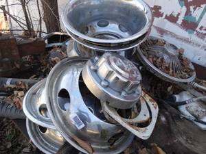 lot 11105 image: Hubcaps and More Misc Contents on top of Worktable  Table - Vise and Anvil Not Included      East of West Barn