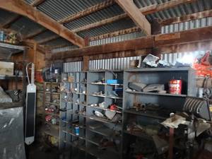 lot 11113 image: Variety of Auto Parts -Tools & Misc  Contents in NW Corner of Barn  Metal Racks w Contents  Items on Wall and Floor  East 12 of West Barn