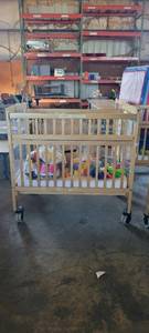 lot 39841 image: Wooden Whitney Evacuation Crib W Assorted Toys and More