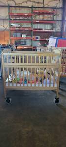 lot 39843 image: Wooden Whitney Evacuation Crib W Assorted Toys, Books, and More
