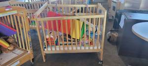 lot 39845 image: Wooden Whitney Fire Safe Crib W Assorted Toys