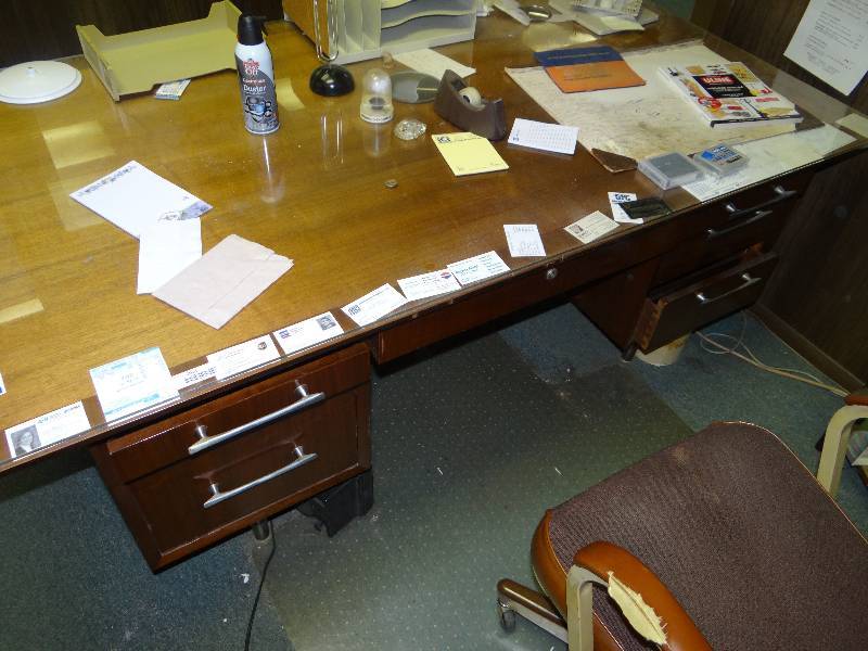 lot 1011 image: Desk With Glass Top, WAll Contents, Chair & Floor Mat.