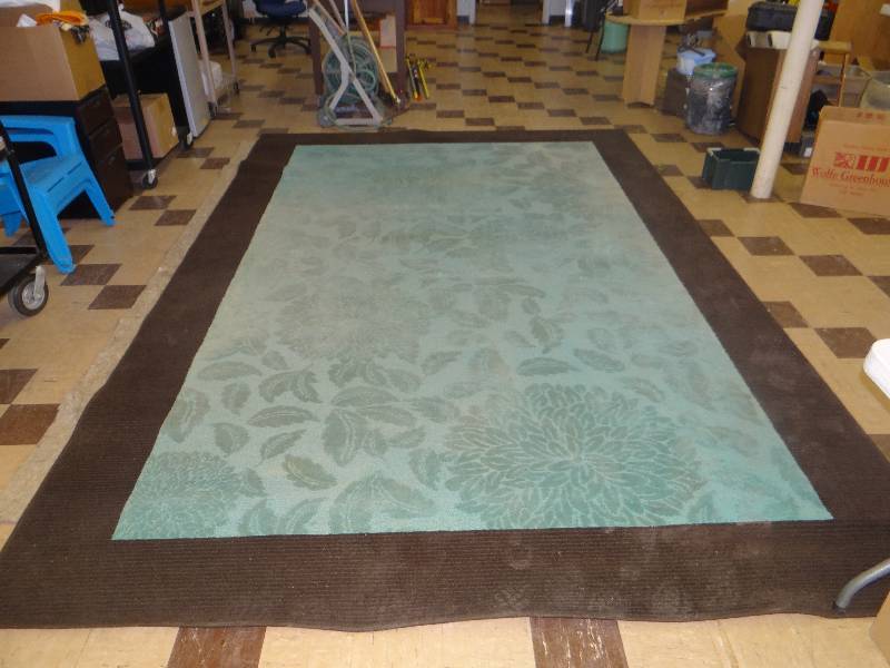 lot 1121 image: Large aqua rug wbrown outer band, has floral design.