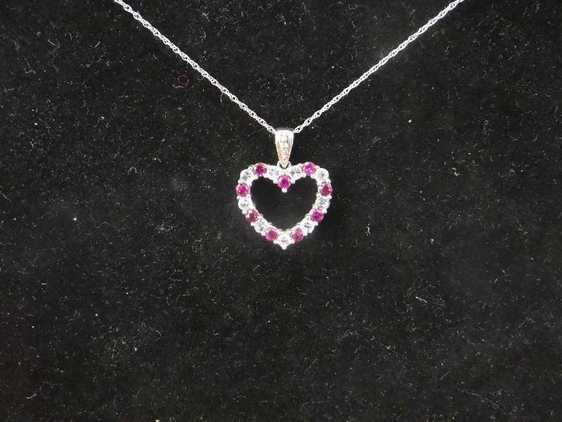 lot 1129 image: Sterling silver heart pendent wpink & clear stones, 10K white gold chain.