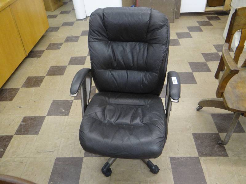 lot 1206 image: Black swivel office chair on casters.