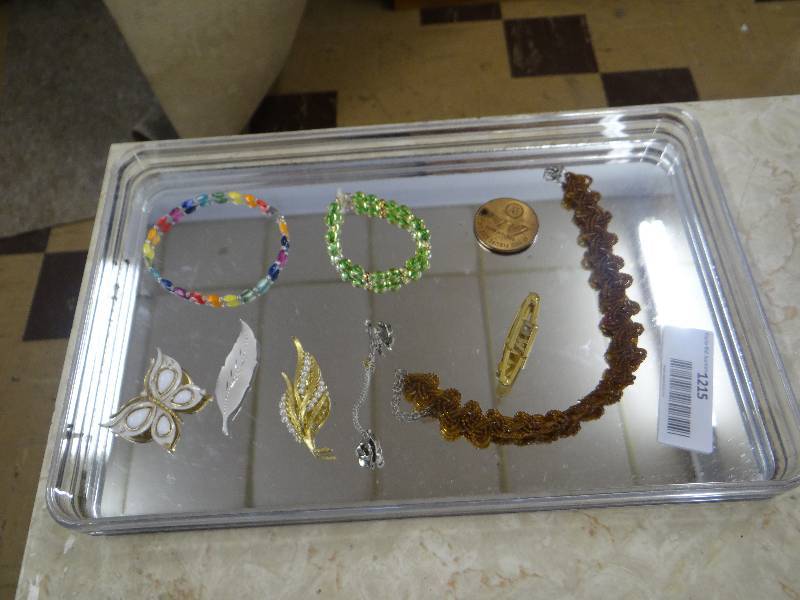lot 1215 image: Mirrored jewelry tray w3 bracelets, 3 pins, 1 necklace, & 1 tie clip.