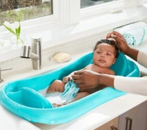 lot 2195 image: First Years Newborn to Toddler Tub w Sling and Gerber Bath Time Essentials