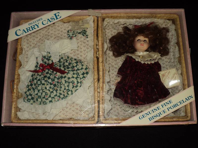 lot 4177 image: Collectors Choice Porcelain doll with basket carrying case- doll does not have eyes.