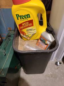 lot 3043 image: Trash can with sand, Preen weed preventer half full and Fertilome weed out half full.