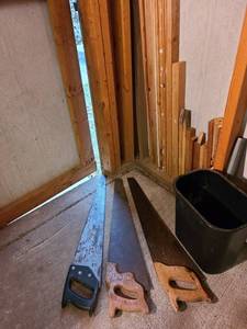 lot 4002 image: Three saws, wood in corner and a trash can