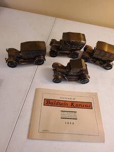 lot 1052 image: Four metal Baldwin City State Bank antique car banks about 6 long and booklet