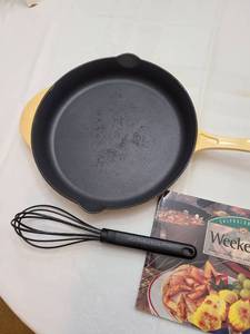 lot 1147 image: Calphalon 12 enamel cast iron skillet custard yellow, nylon whisk and Weekends cookbook