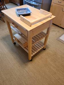 lot 1195 image: Kitchen island with drawer, pull-out cutting board on casters 34 x 29 x 21.5. Extra attachments included.