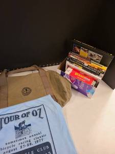 lot 1107 image: Lance Armstrong books, 1977 Oz Bicycle Club t-shirt size large, Sierra Club bag