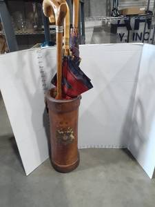 lot 1192 image: Wooden umbrella holder. Approximately 20 inches tall. With (3) umbrellas and a cane