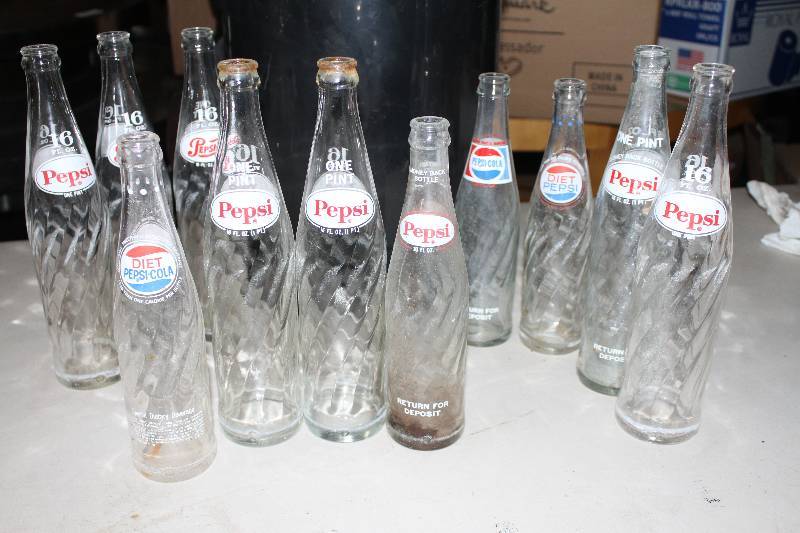 lot 86 image: Old Pepsi bottles and black step trash can