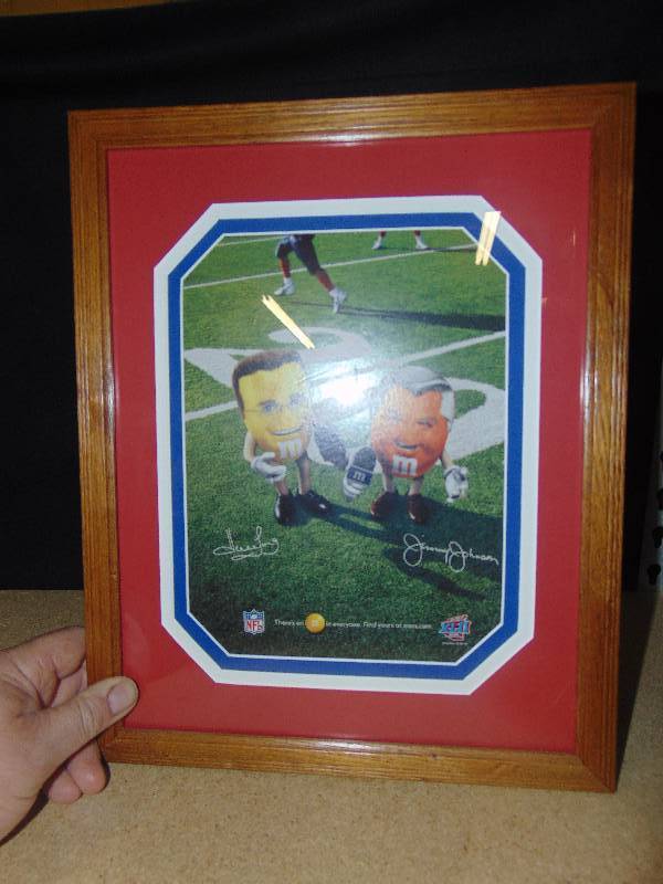 lot 4134 image: M&Ms Howie Long & Jimmy Johnston  advertising picture, professionally matted and framed, 12 x 15