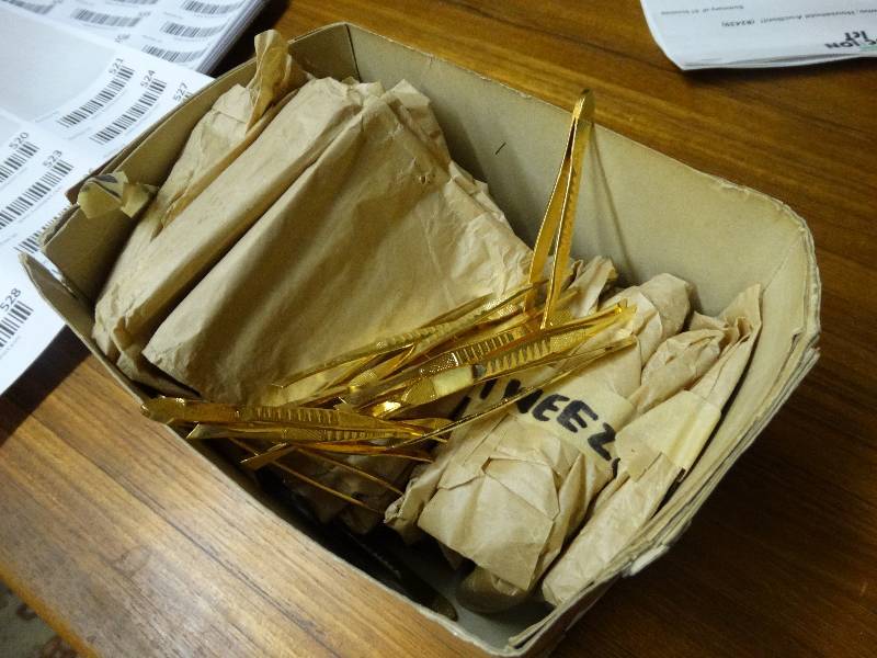 lot 519 image: Box of gold color tweezer.