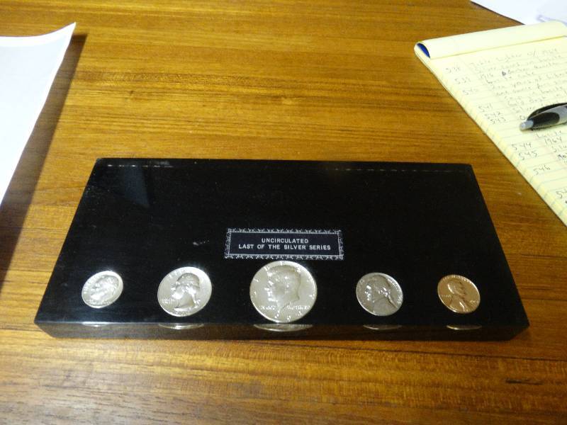 lot 549 image: Uncirculated last of the silver series silver coins in lucite.