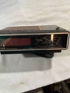 lot 7748 image: LYNX AMFM clock, radio lights up untested further in metal building