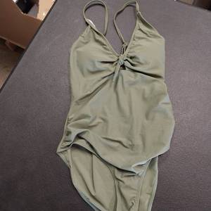 lot 7517 image: Girls one piece knot bathing suit olive green size 13 before 10 years.