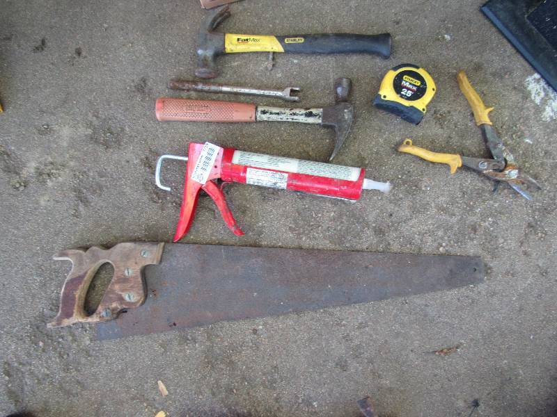 lot 7715 image: Lot of Misc. Tools - 2 hammers, caulking gun, Stanley 25 tape measure, Tin snips and Hand Saw