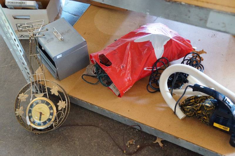 lot 122 image: Contents of bottom shelf shop vac, bedding, banjo clock, how to cassette set, hanging lights.