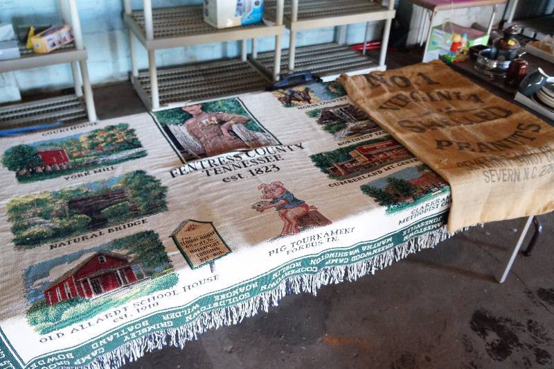 lot 129 image: Blanket that says Tennessee, & a shelled peanut bag.