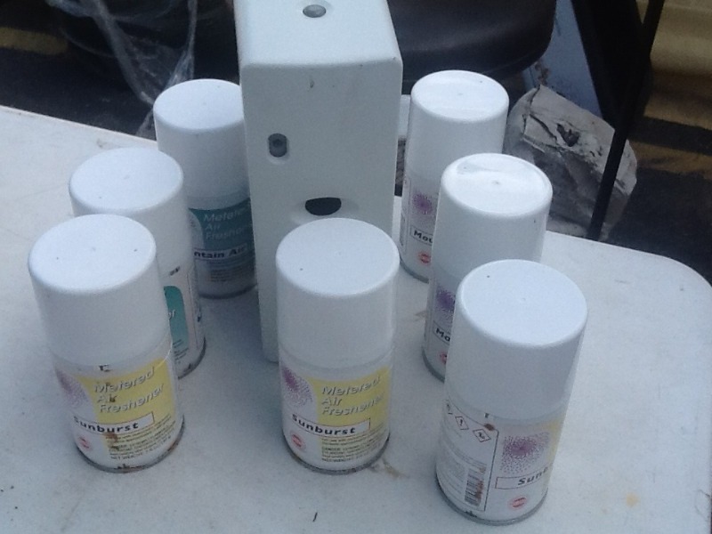 lot 7867 image: Wall air freshener automatic sprayer with cans of air freshener as pictured