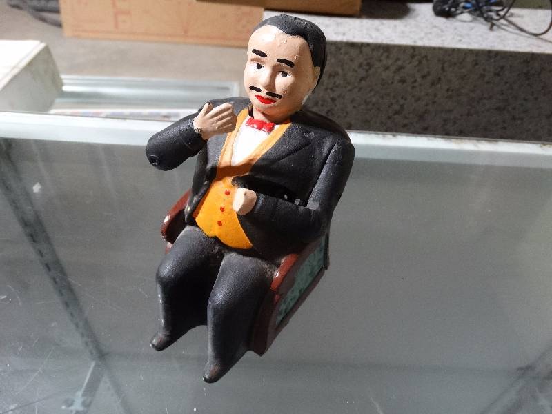 lot 460 image: cast iron man in tux in rocking chair bank