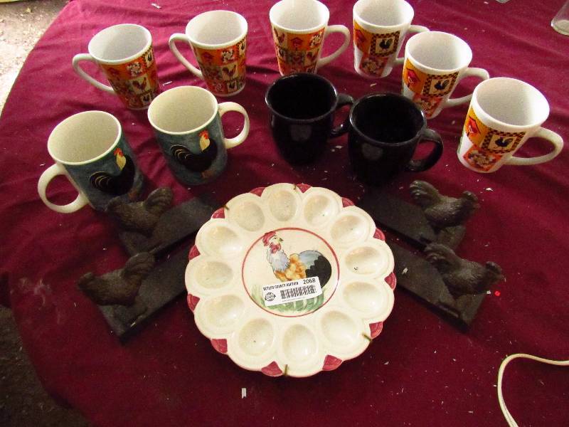 lot 2068 image: Rooster Themed Kitchenware - 10 coffee cups, 4 metal (cast iron) cook book ends, Deviled Egg Plate - Neat lot