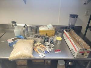 lot 18635 image: Assorted Lot of Kitchen Supplies - Sysco Classic Plastic Food Wrap, Stainless Steel Taco Holders, Hamilton Beach 50190 Blender, and More