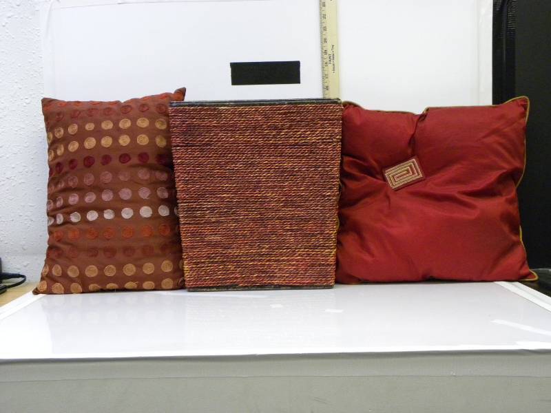 lot 7028 image: 2 Red Tone Pillows. Handled Wood and Red Rope Bucket.
