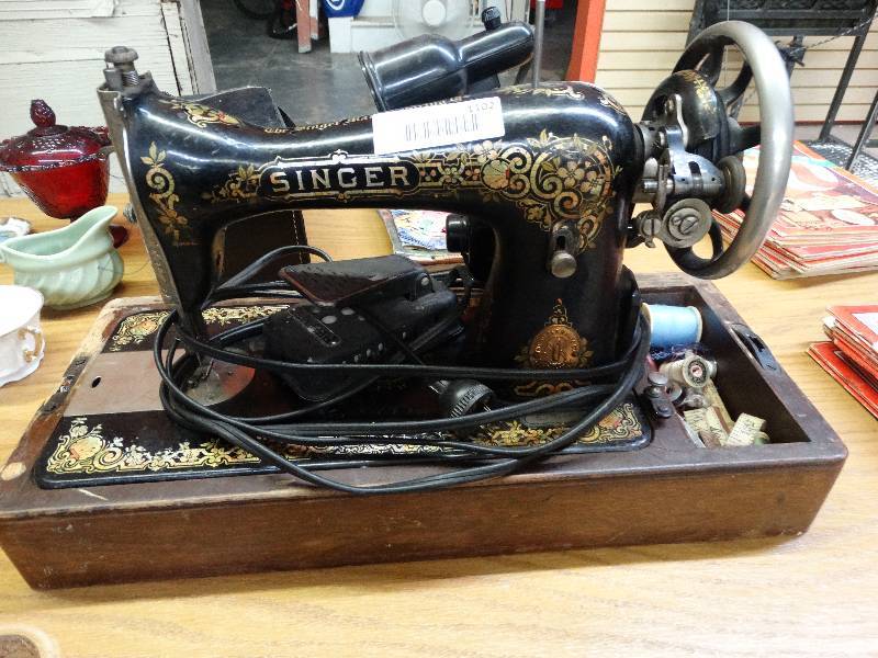 lot 1102 image: Vintage singer sewing machine with wooden base.