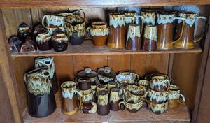 lot 790 image: Vintage Brown Drip Glaze Cups, Pitchers, S&P Shakers, Mugs, and Lidded Dishes.