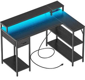 lot 14250 image: SUPERJARE L Shaped Gaming Desk with LED Lights & Power Outlets, Reversible Computer Desk with Shelves & Drawer, Corner Desk Home Office Desk, Black Retail $120