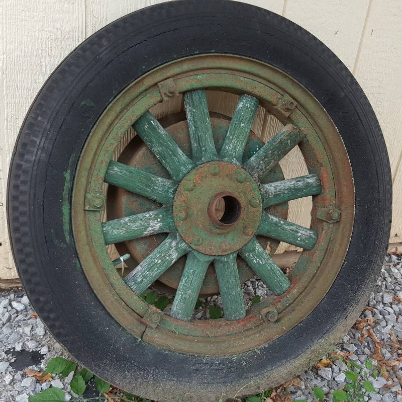 lot 6549 image: Your guess is as good as mine.  Old wood front tire and wheel with the brake drum still bolted to it.