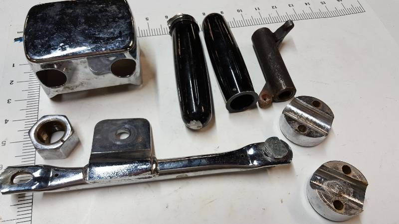 lot 6719 image: Miscellaneous motorcycle parts in a box including handle bar clamps, chrome regulator cover, handle bar grips