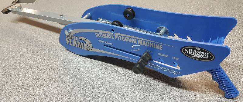lot 6476 image: Hand held Louisville Slugger Triple Flame Pitching Machine with very little use