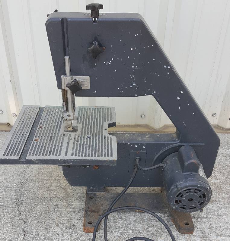 lot 6426 image: Table top 12 throat band saw missing the blade and plastic side cover.  No clue as to what happened to the side cover
