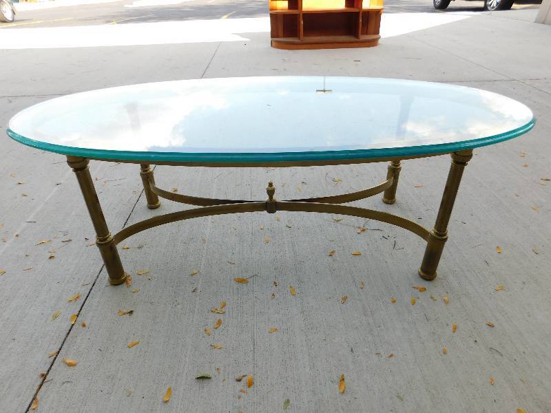 lot 8274 image: 16 T, 49  23 Oval Glass Coffee Table. Unpolished Brass Frame.