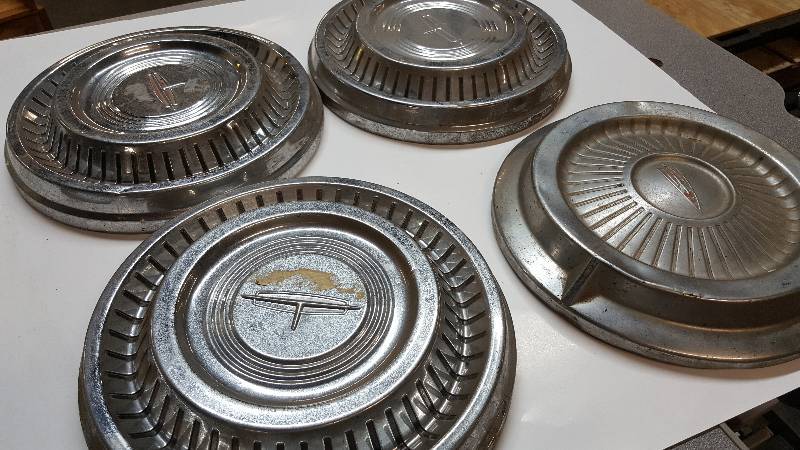 lot 6413 image: I believe these 4 hub caps are a couple different years Oldsmobile