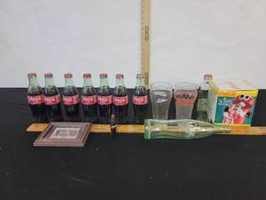 lot 249 image: Full Coca-Cola Bottles, Drinking Glasses, Action Bank And More