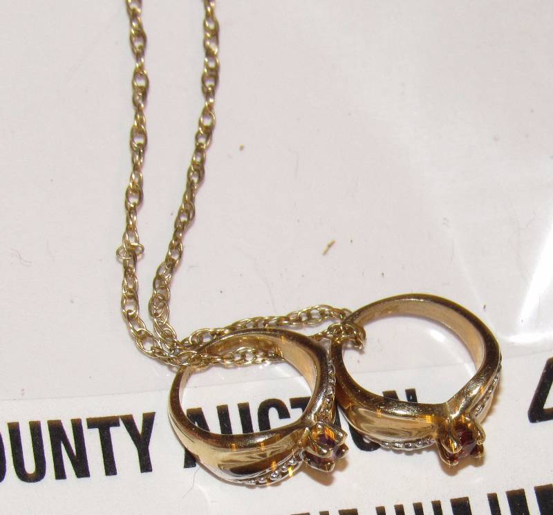 lot 4545 image: Gold Necklace w 2 small gold rings on it w diamonds and red stones. Marked 14K