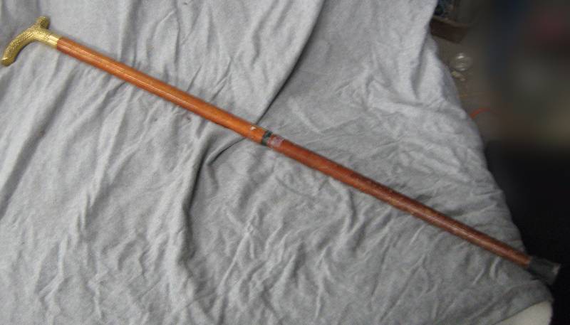 lot 2573 image: Cane w removable brass handle - has a crack in the middle where is unscrews to come apart)