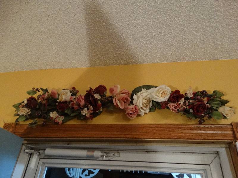 lot 747 image: Floral arrangement above door & hanging doll