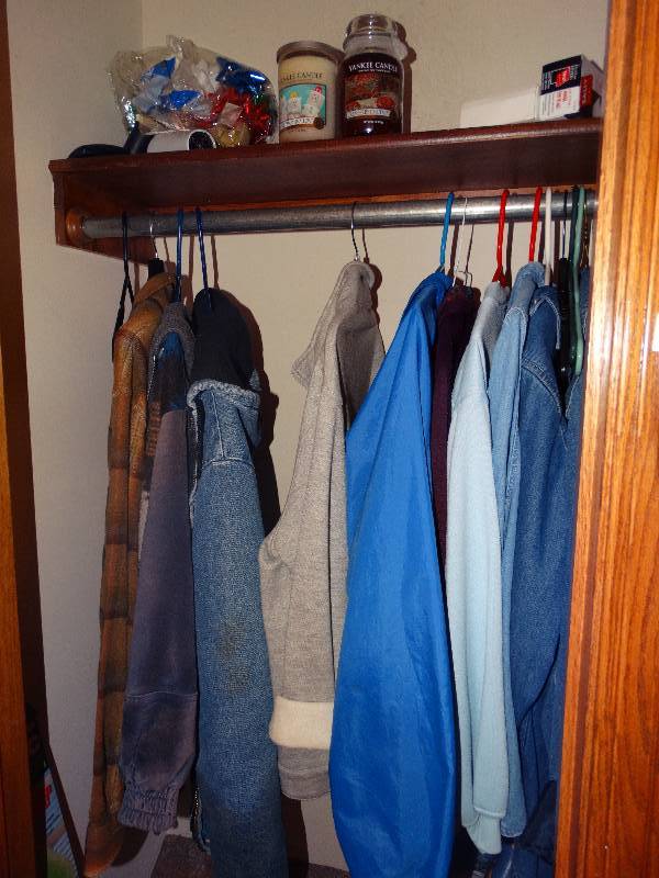 lot 749 image: Contents of closet- Yankee candles, clothes, misc.