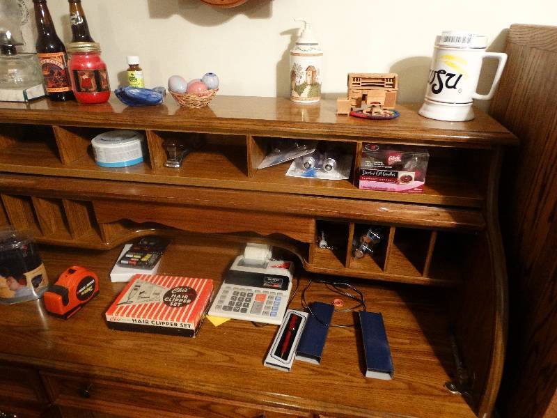lot 947 image: Contents of Roll Top Desk - Tape Measure, Calculator, Pens, Light bulbs, Beer Bottles, Lantern, & misc.