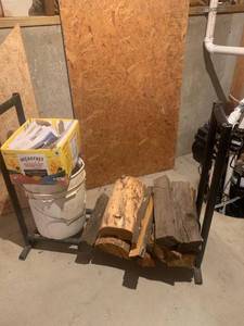 lot 2041 image: Firewood holder with firewood and newspapers. 31 x 37 x 15. Located in the basement