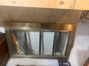 lot 2055 image: Glass fireplace front. Approximately 29.5 x 46. With extra parts. Located in the basement